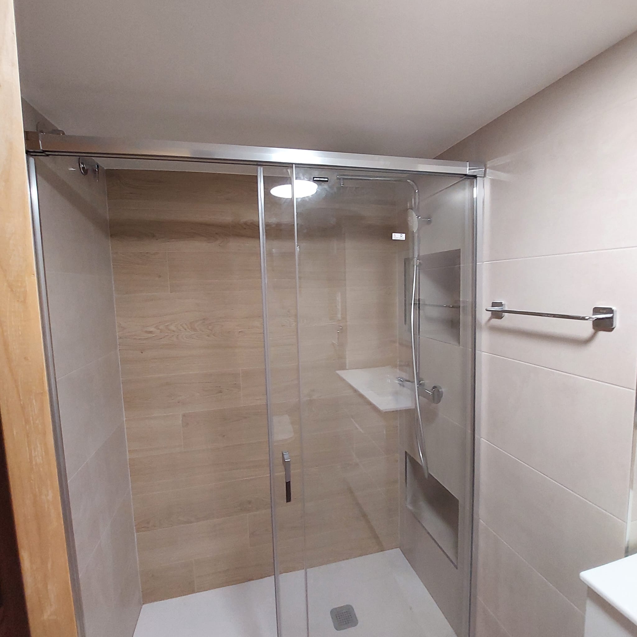 Baño reformado moderno en Elche con ducha de obra y mueble flotante